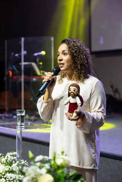 Márcia, artesã e criadora do método, segurando um Jesus de crochê na igreja